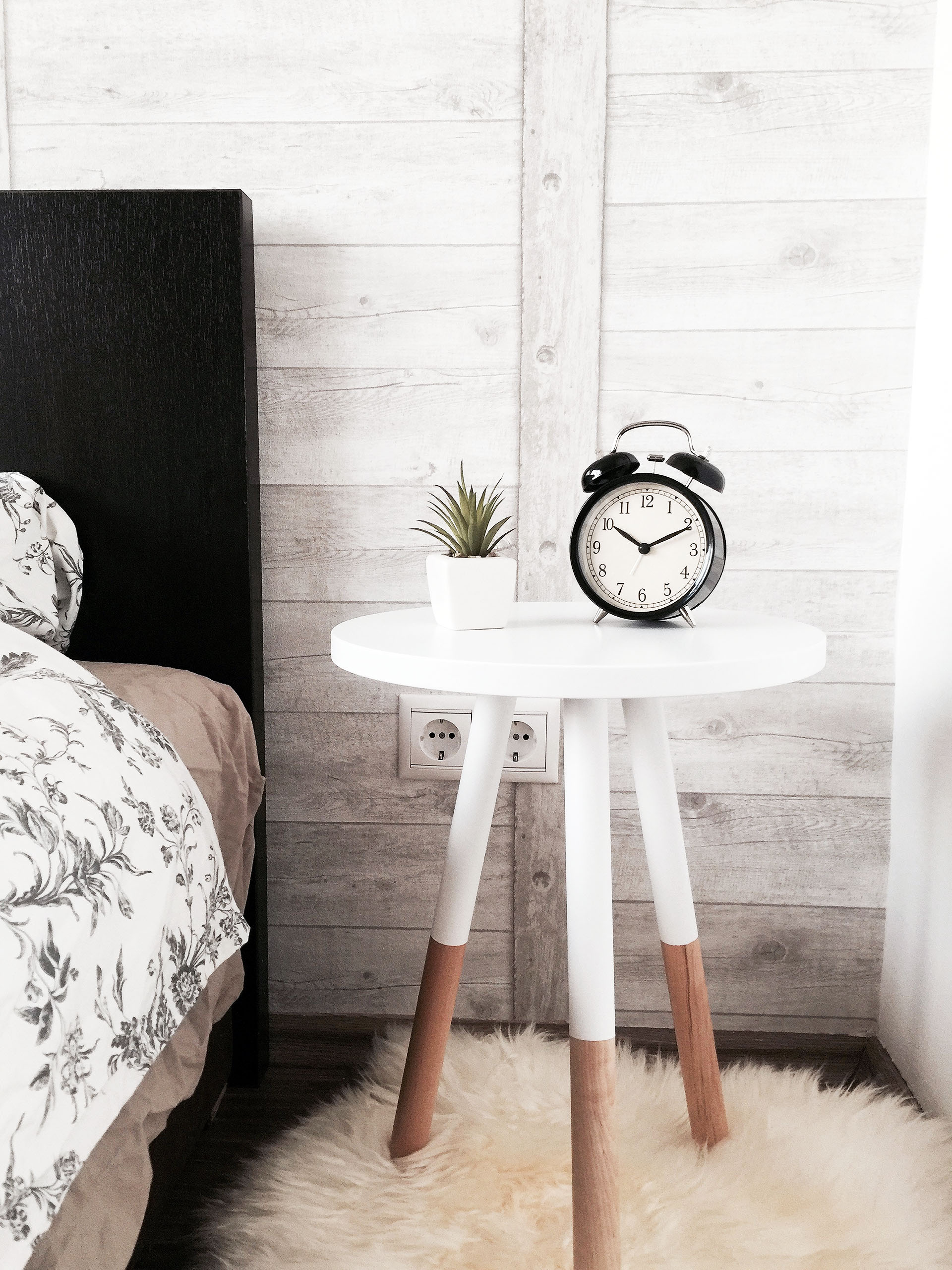 How to make your home cosy when renovating - image of a table on a cosy rug beside a bed